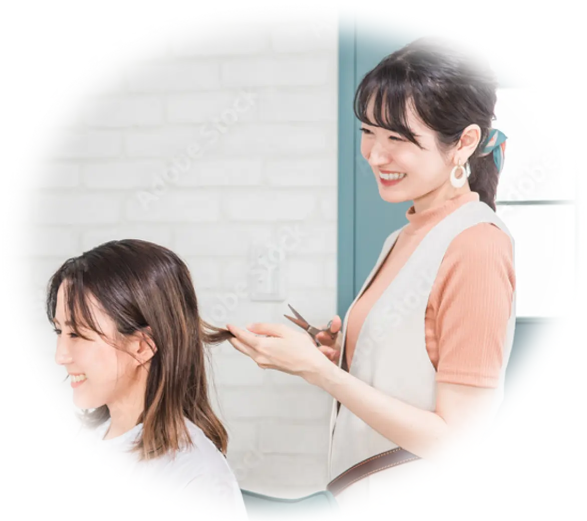 美容師が女性の髪をカットしている様子